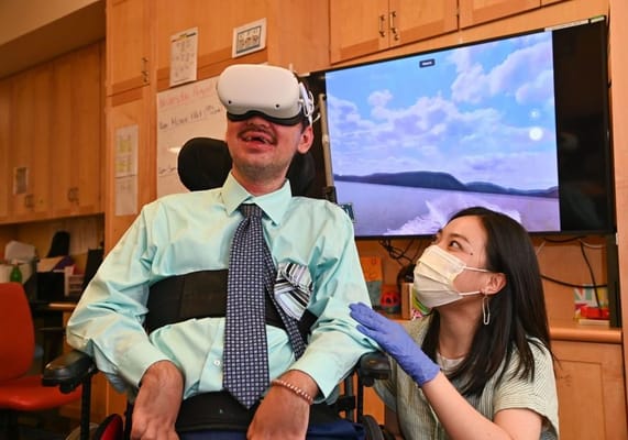 Resident experiencing virtual reality with staff assistance