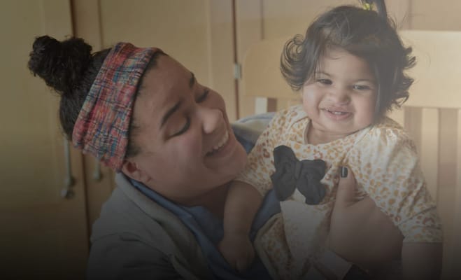 Caregiver happily holding a toddler