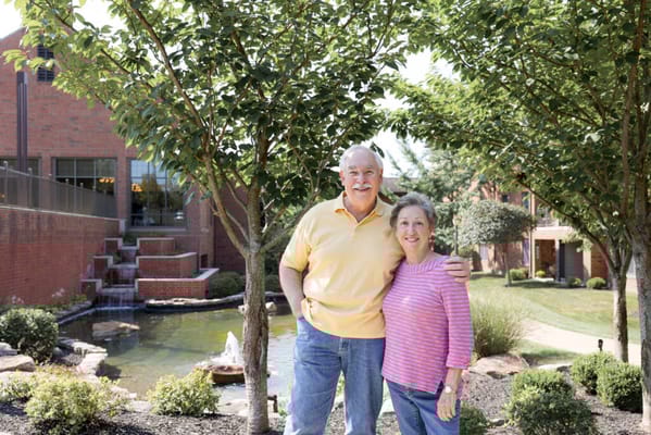 Two residents smiling in a landscaped outdoor area