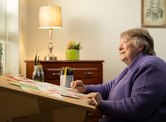 Senior resident engaged in an art activity at a desk