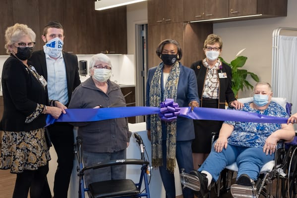 Staff and residents celebrating a ribbon-cutting event