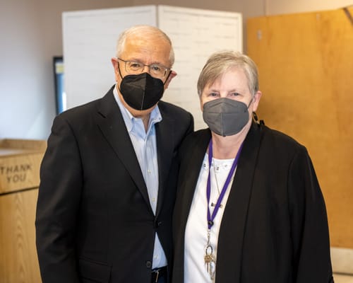 Two residents posing for a photo indoors