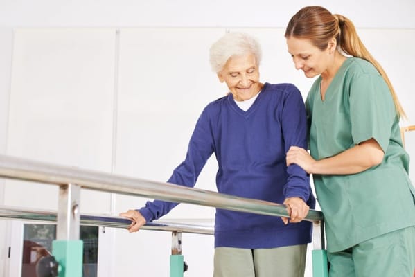 A caregiver assisting an elderly resident during therapy