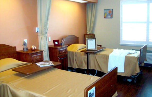 A shared resident room with two beds and furniture