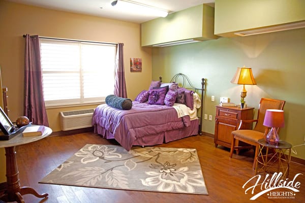 Cozy resident room with purple decor and wooden flooring
