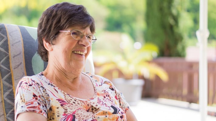 Smiling resident enjoying outdoors in a chair