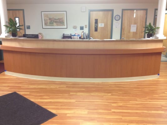 Reception area with wooden counter and plants