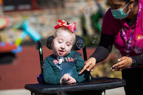 A staff member playing with a resident in a garden