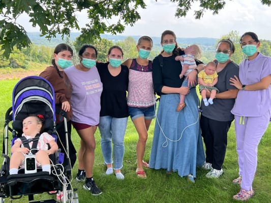 Group of staff and residents outdoor, wearing masks