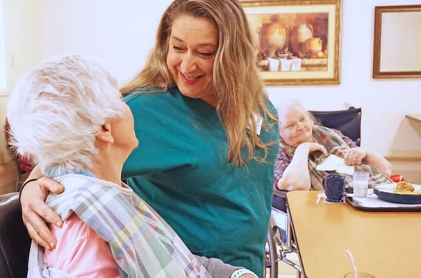 A caregiver interacting joyfully with a resident
