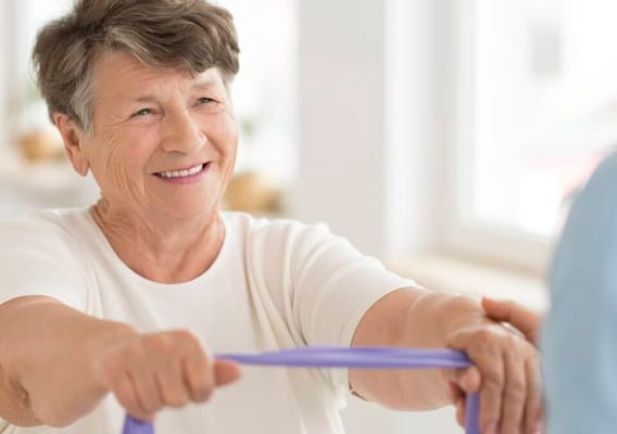 Senior woman engaging in physical therapy with resistance band