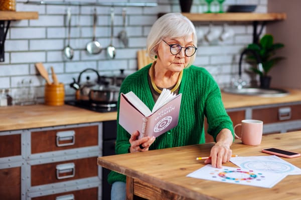 Resident engaging with a book at a table