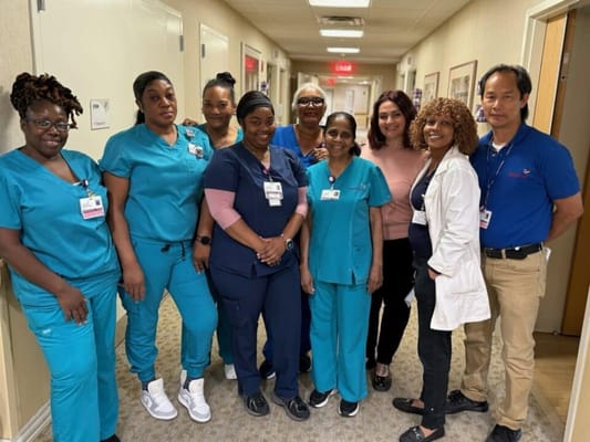 Staff members posing in a facility hallway