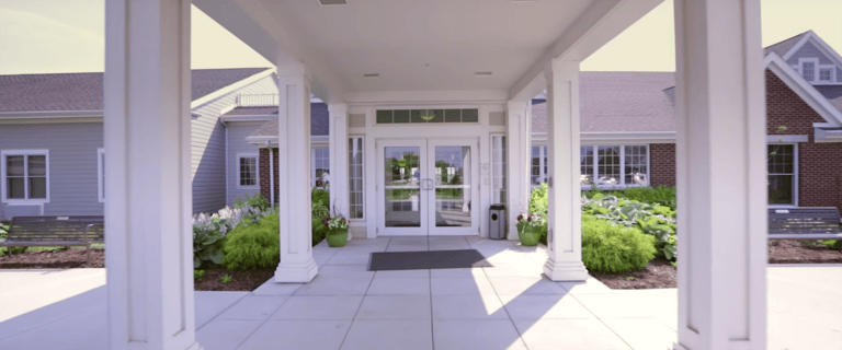 Entrance of a senior living facility with gardens