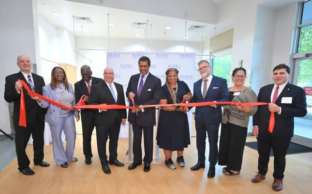 People cutting a ribbon at a facility opening event