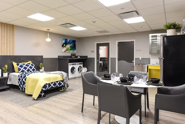 A modern room setup with a dining area and laundry.
