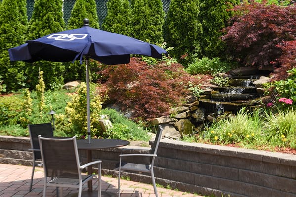 Outdoor seating area with a garden and water feature