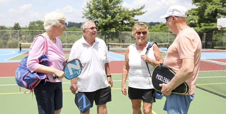 Seniors enjoying a game of pickleball outdoors