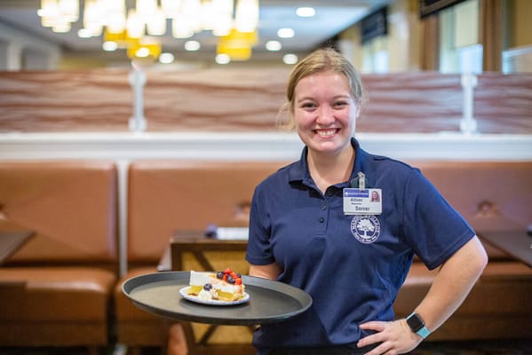 Staff member serving dessert in the dining area
