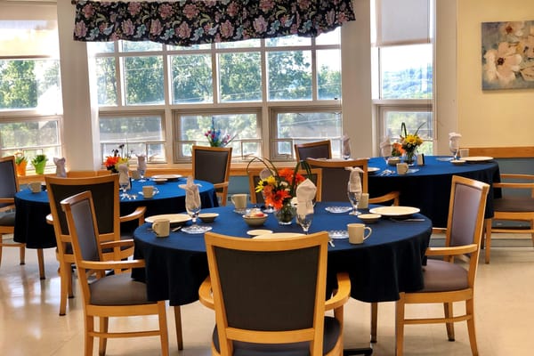 Bright dining room setup with flowers and table settings