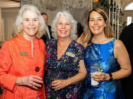 Three residents enjoying drinks at a celebration