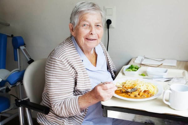 A resident enjoying a meal in their room