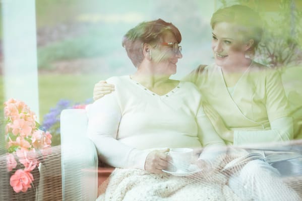 A resident and caregiver sharing a moment indoors