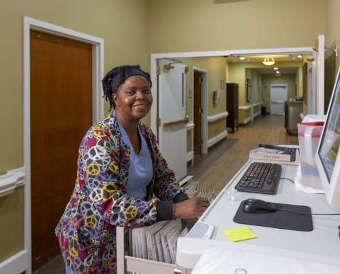 Staff member organizing files in a facility hallway
