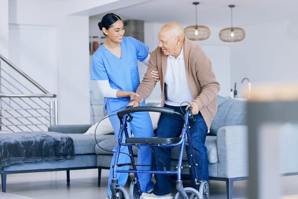 Healthcare worker assisting an elderly man with a walker