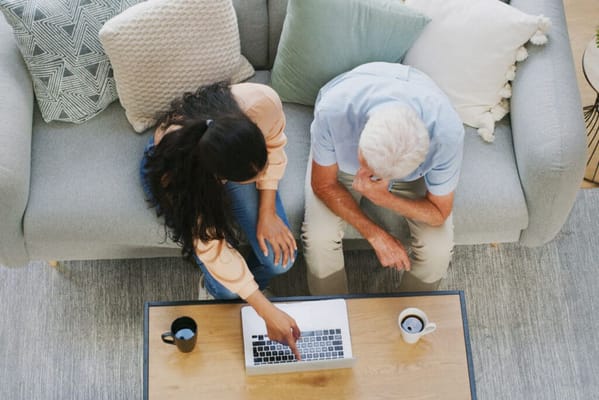 Senior resident and staff member using a laptop together