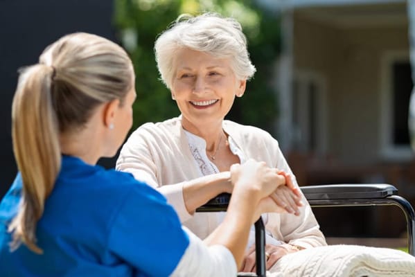 Staff member holding hands with a smiling resident