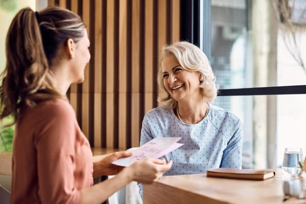 A caregiver and resident enjoying a conversation indoors