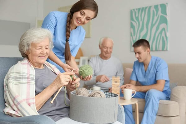 Residents and staff engaging in a knitting activity