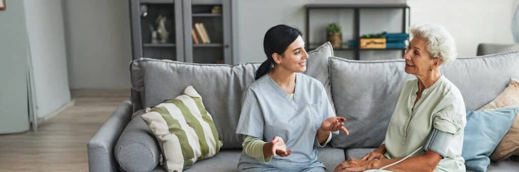 Caregiver conversing with a resident in a cozy setting