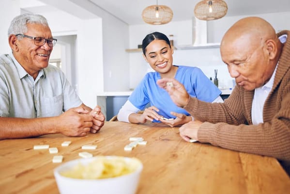 Residents and staff playing a game at a table