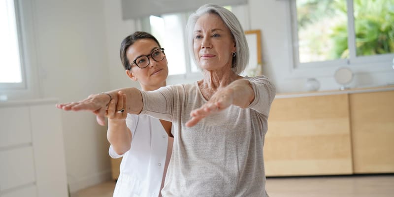 A staff member assisting a resident with exercises