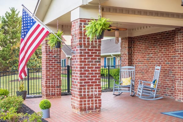 Patio area with rocking chairs and American flag
