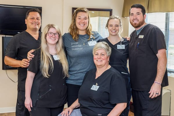 Staff members posing together in a facility