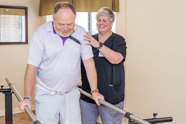Staff assisting a resident in a rehabilitation session