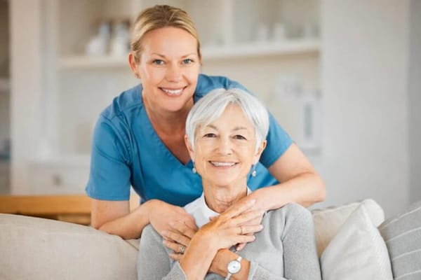 Nurse and resident smiling together in a cozy setting