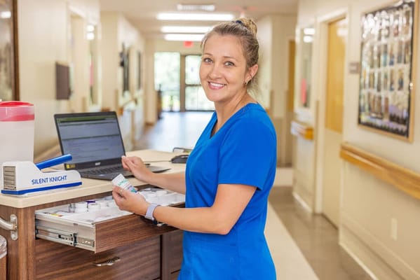Staff member assisting with medication at a nursing facility