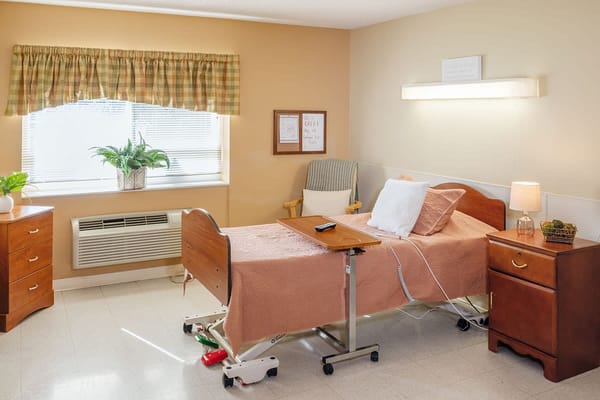 Cozy resident room with a hospital bed and furniture
