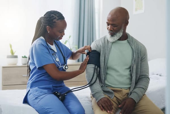Nurse taking a patient's blood pressure in a bright room