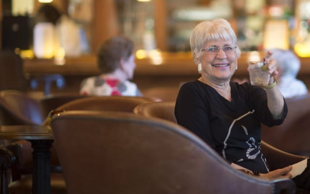 Smiling resident enjoying a beverage in a common area