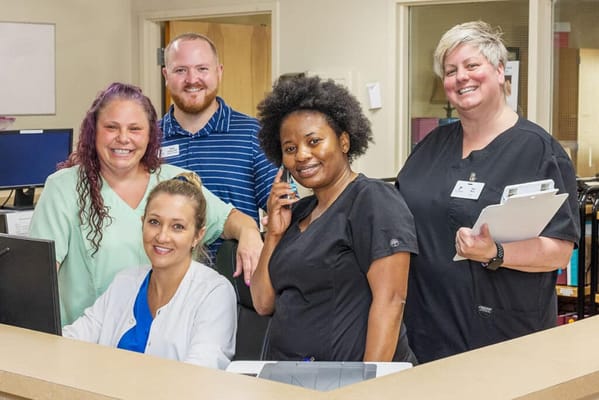 Staff members smiling at the reception desk