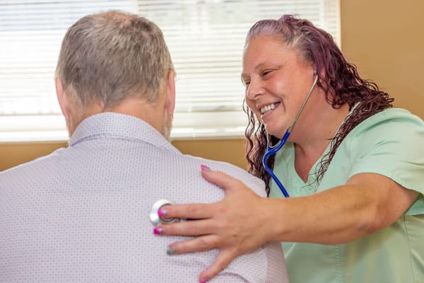Healthcare professional using a stethoscope with a resident