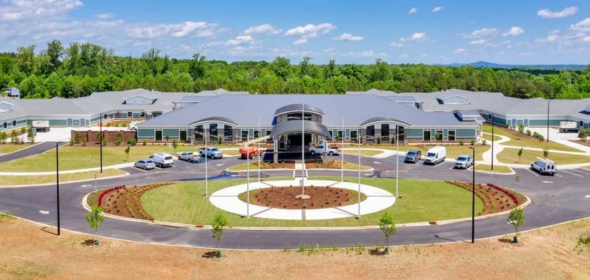 Aerial view of the assisted living facility with gardens and vehicles
