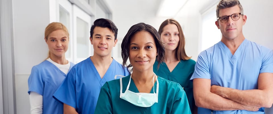 Medical staff posing together in a bright corridor