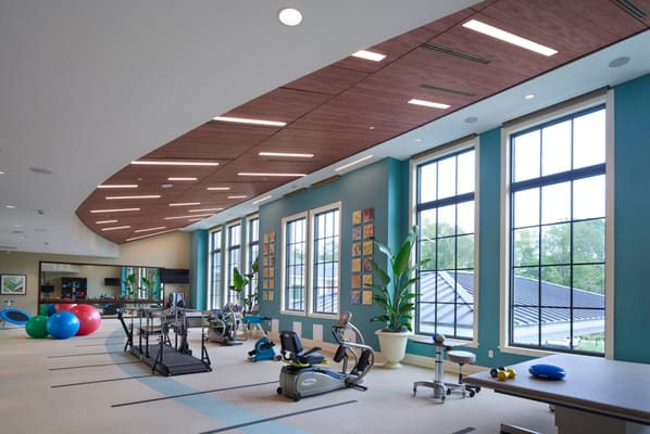 Modern fitness area with equipment and windows