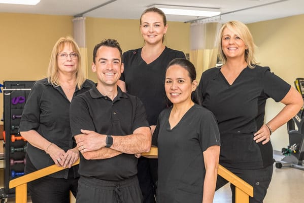 Staff members posing together in a therapy room